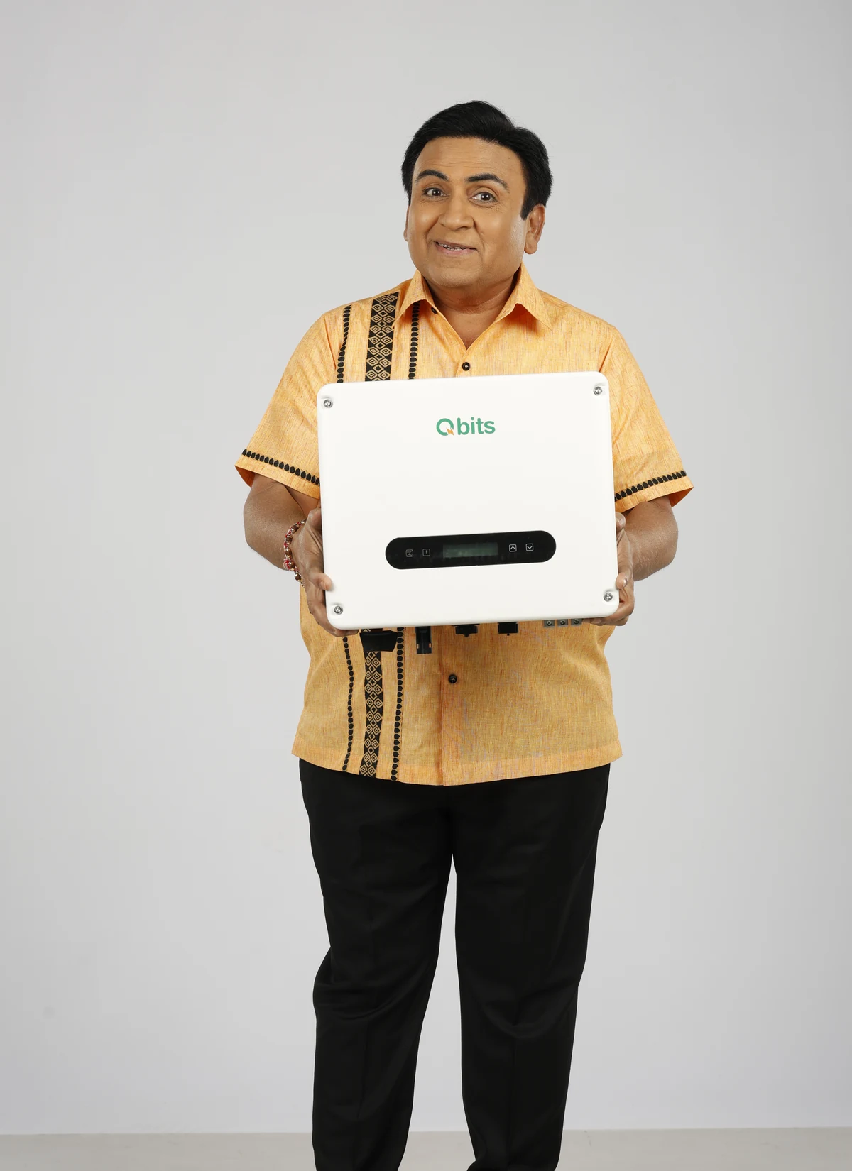 Dilip Joshi, Brand Ambassador of Qbits Energy, holding a Qbits solar inverter