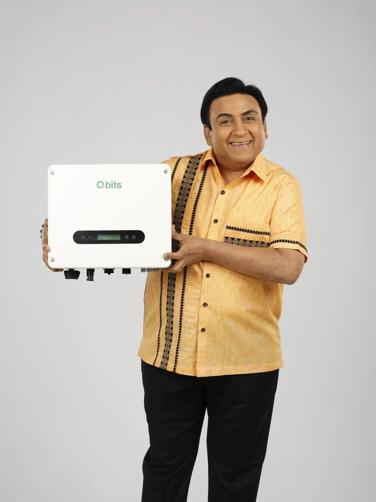 Dilip Joshi, Brand Ambassador of Qbits Energy, holding a Qbits solar inverter