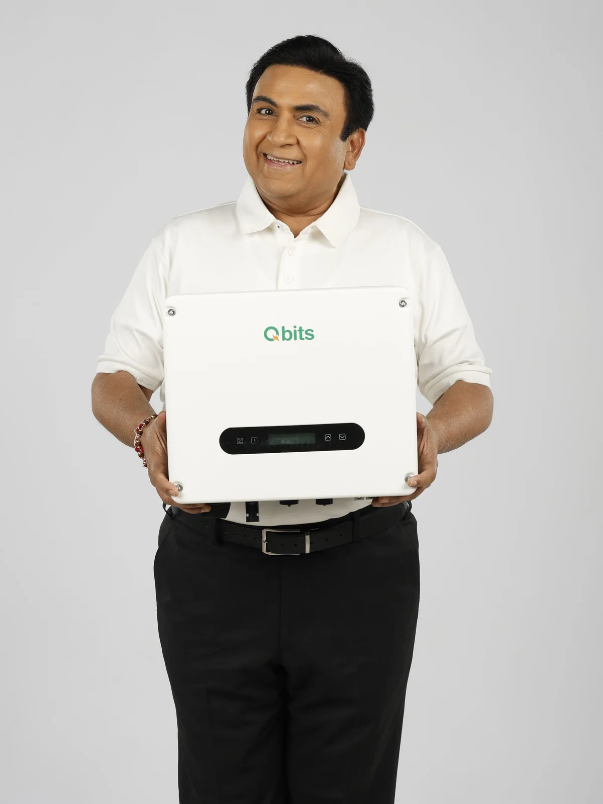Dilip Joshi holding a Qbits on-grid inverter