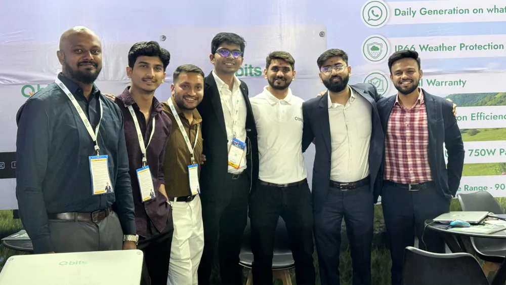 The Qbits Energy team standing together at their exhibition booth in Varanasi