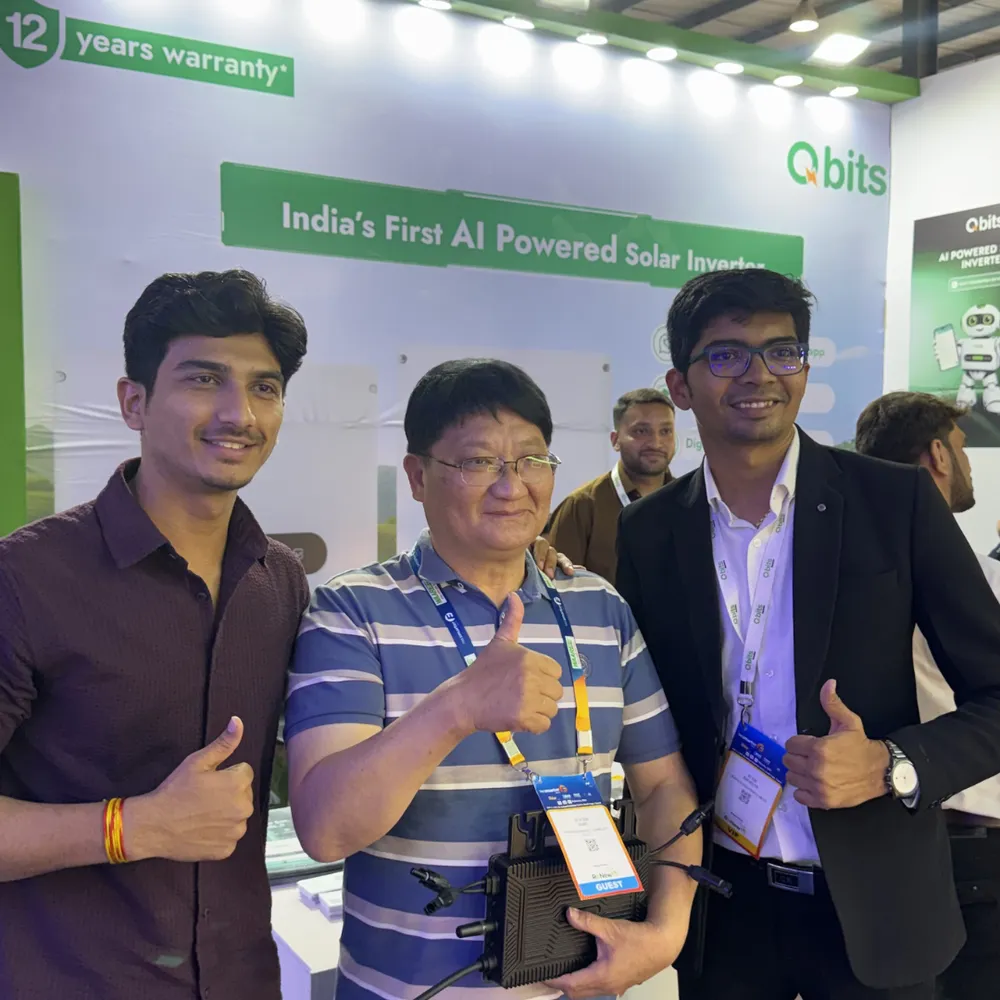 Qbits team members demonstrating solar inverter hardware to a visitor at the exhibition stall