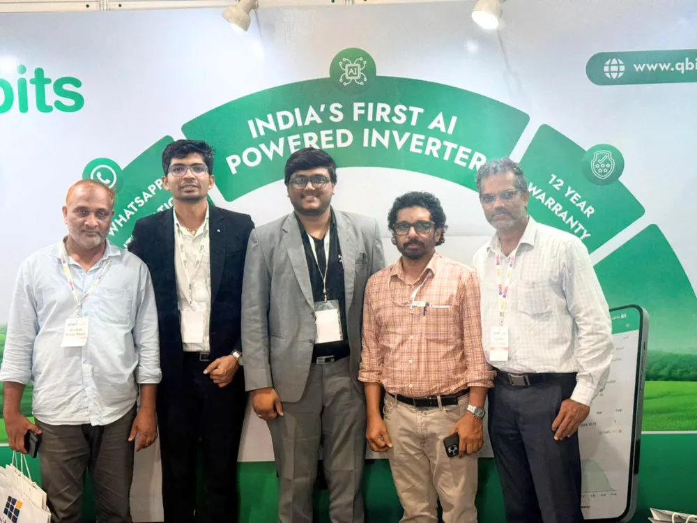 Visitors standing with the Qbits team in front of the India’s First AI Powered Inverter backdrop at the Qbits stall