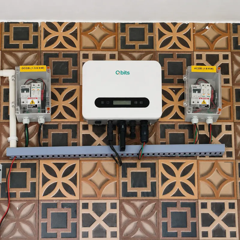 Qbits solar inverter mounted on a patterned jali tile wall with DCCB and ACDB enclosures